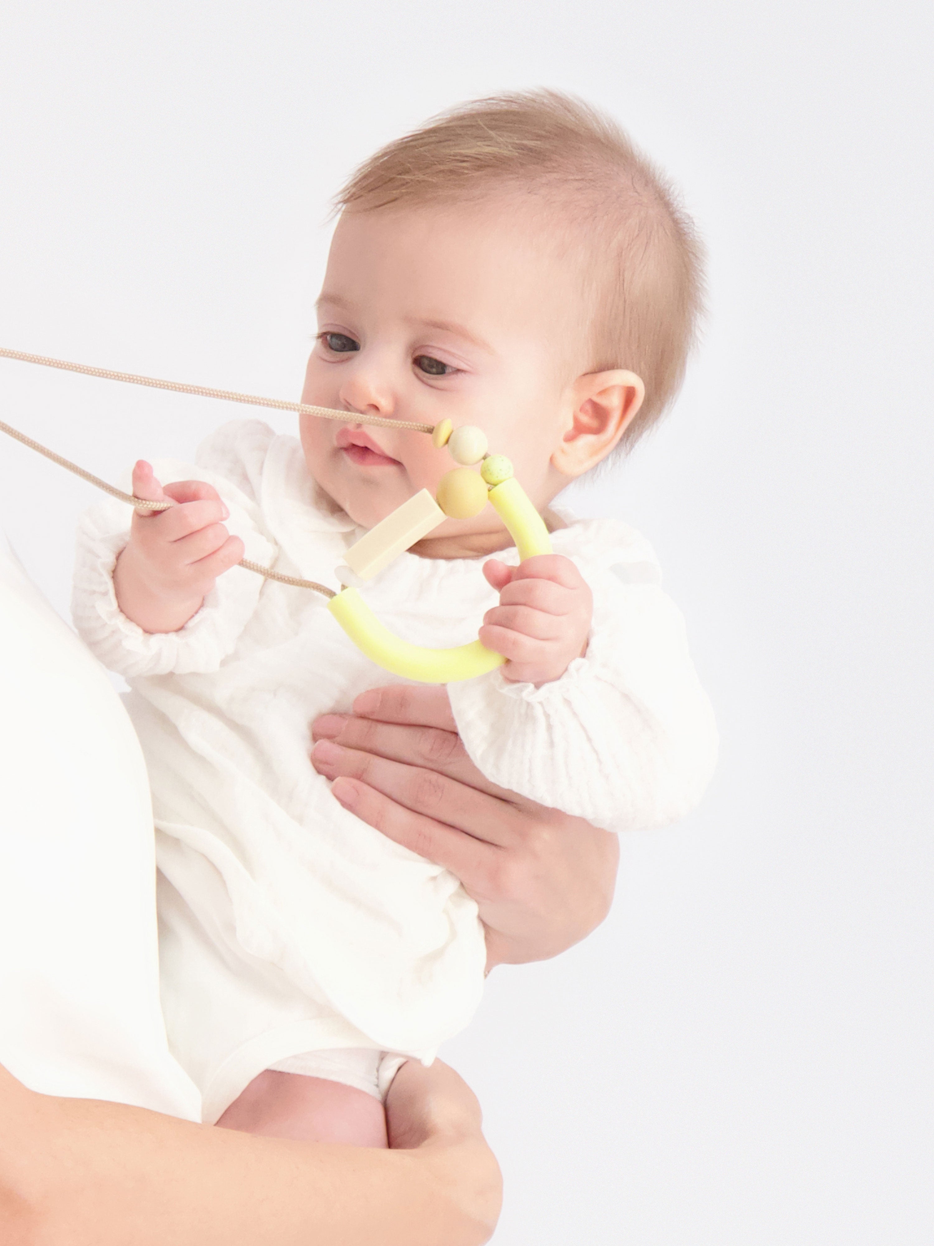 Baby interacting with our Bloom Teething Necklace in the Anise Flower colorway.